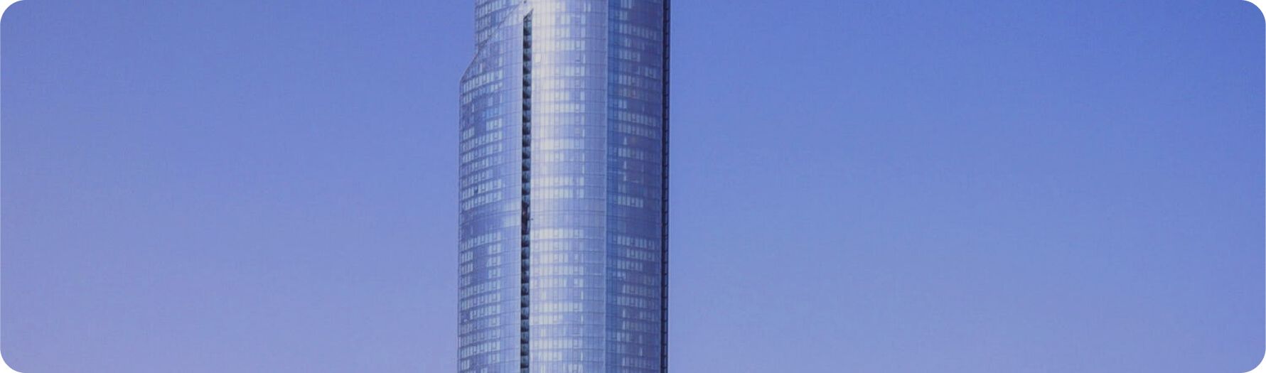Modern glass office tower against a blue sky